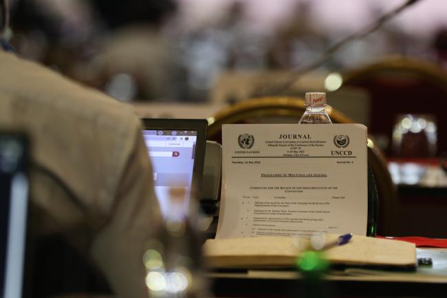 On the penultimate day of UNCCD COP 15, delegates review the schedule for the day as negotiations continue in contact groups