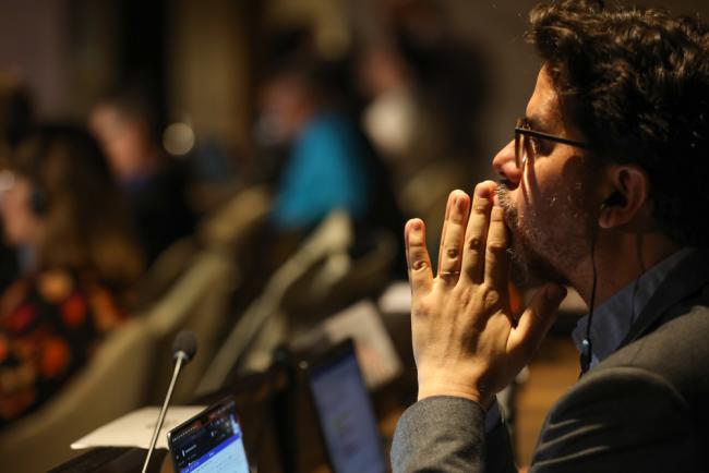 Delegates listen to the deliberations in the contact group