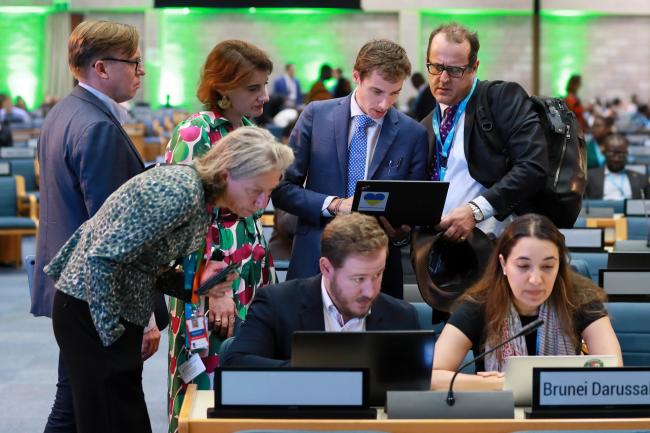 Delegates convene in a huddle before the morning plenary