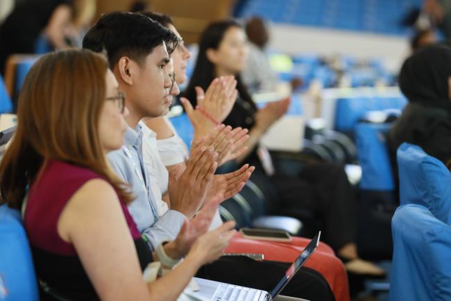 Delegates applauding the adoption of the meeting report