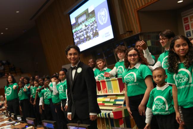 Children from 'Sing for Hope' perform a song during the closing, played on the SDG piano