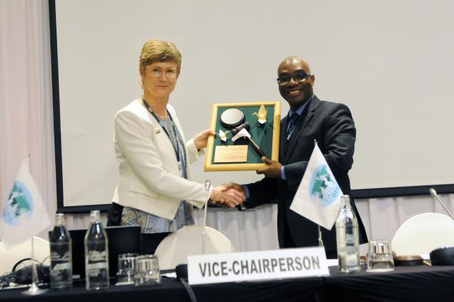 ITTC-60 incoming Chair Anna Tyler, New Zealand, presents a framed gavel to outgoing ITTC-59 Chair Mohammed Nurudeen Iddrisu, Ghana