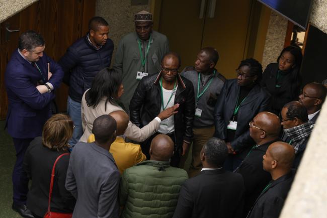 Delegates from the African Group huddle in the corridors as debate continues throughout the day regarding the terminology of Indigenous Peoples and local communities (LCIPs)