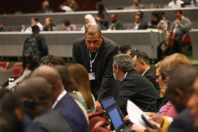 Delegates from Chile consult informally as different agenda items are discussed throughout the day