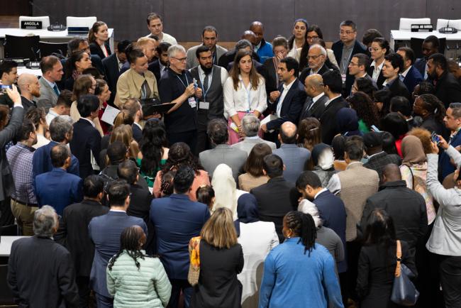 As the June Climate Conference enters its final days, delegates huddle during informal consultations on the Just Transition Work Programme