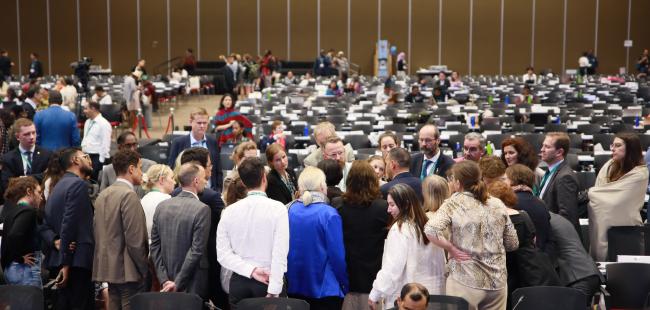 Delegates forming a huddle during the evening plenary