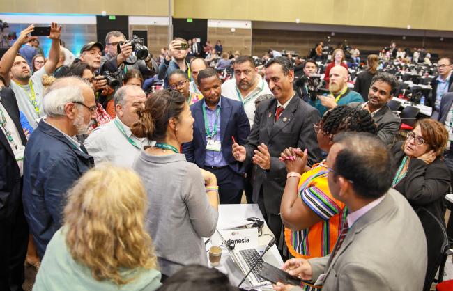 Delegates huddled during the evening plenary